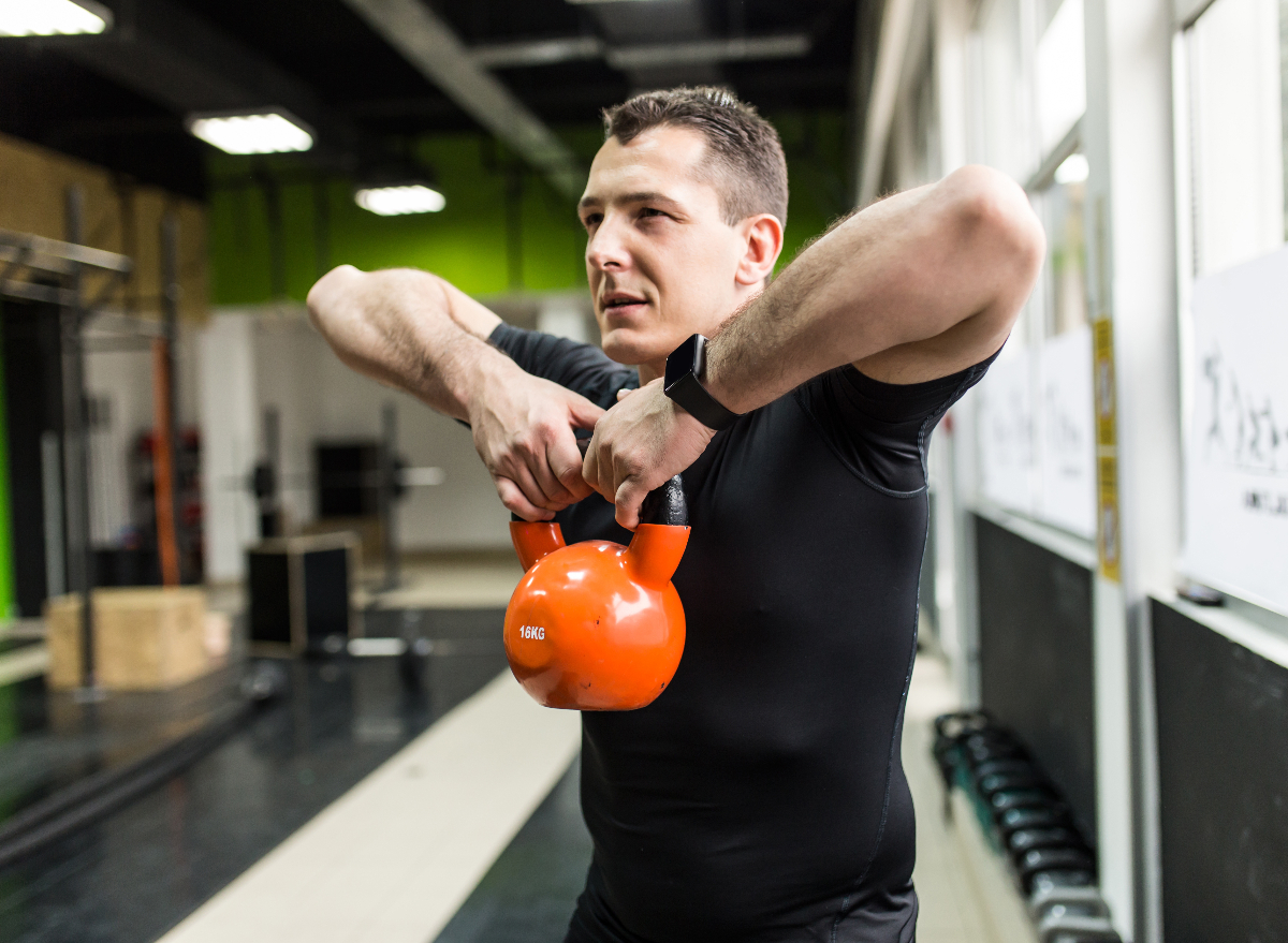 man demonstrating kettlebell workout to get rid of your belly overhang