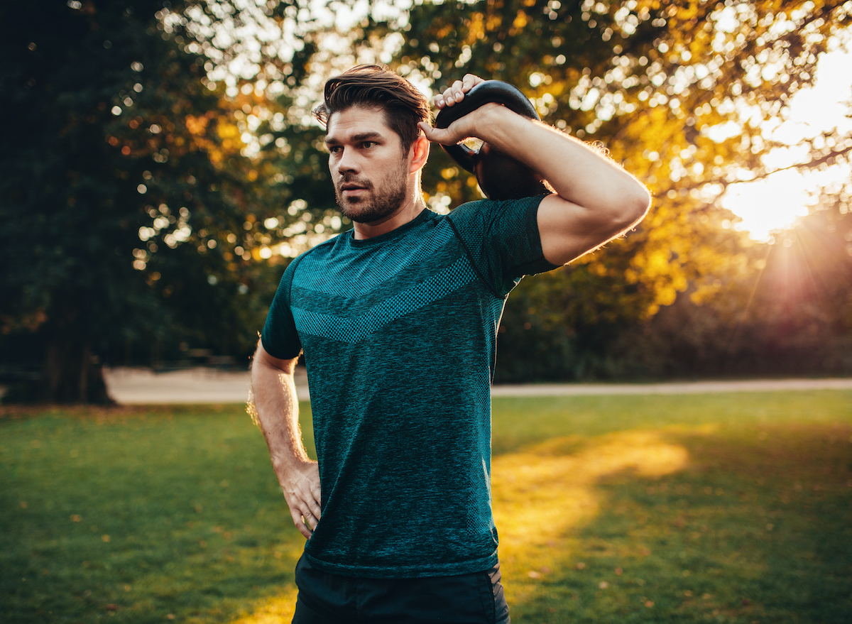 man performing outdoor kettlebell workout, demonstrating how to lose a big belly for good