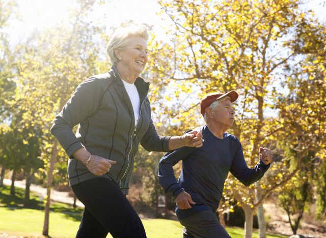 mature couple power walking, demonstrating exercises to shrink hanging belly fat