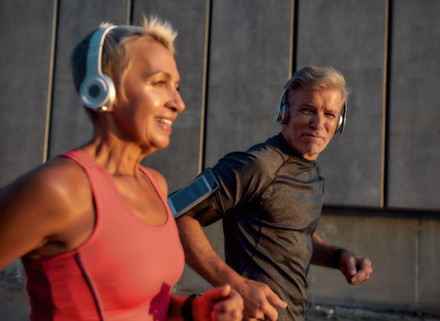 mature couple running outdoors at sunset, one of the leisure activities that extend your life