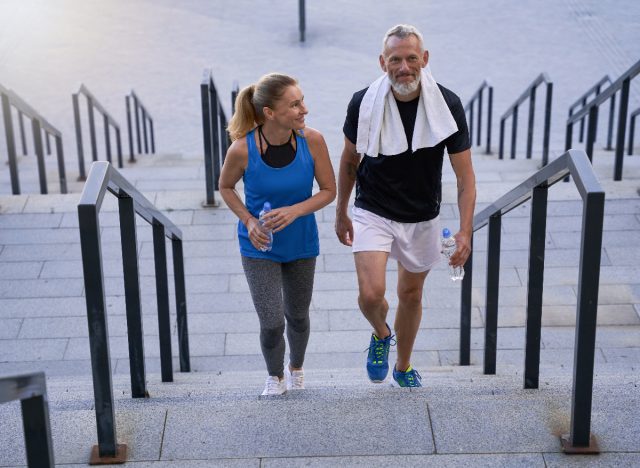middle-aged couple taking the stairs, walking habits that slow aging