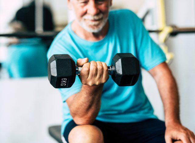 mature man lifting heavy dumbbell, exercise habits to slow muscle aging