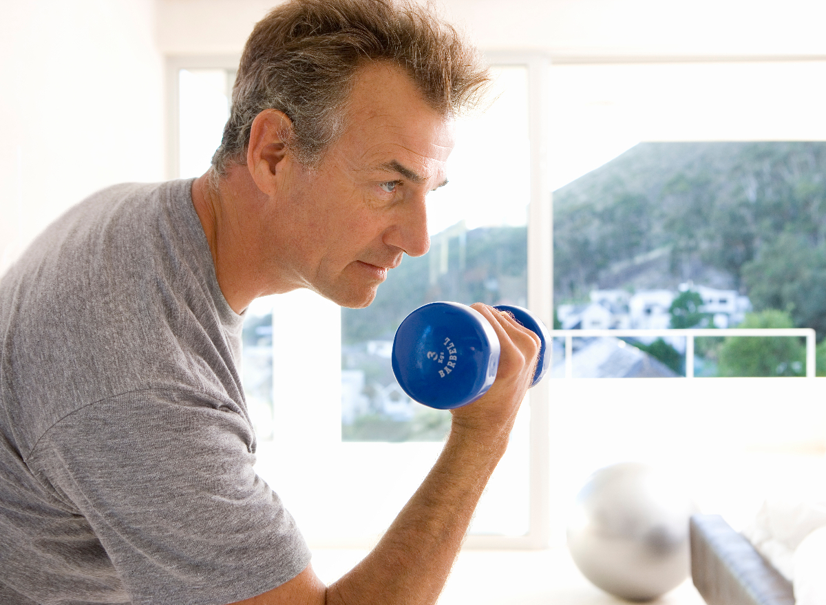 mature man lifting weights to slow down aging after 50