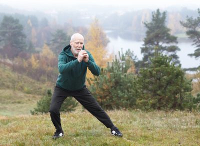 mature man doing side lunges, demonstrating exercise habits to slow muscle aging