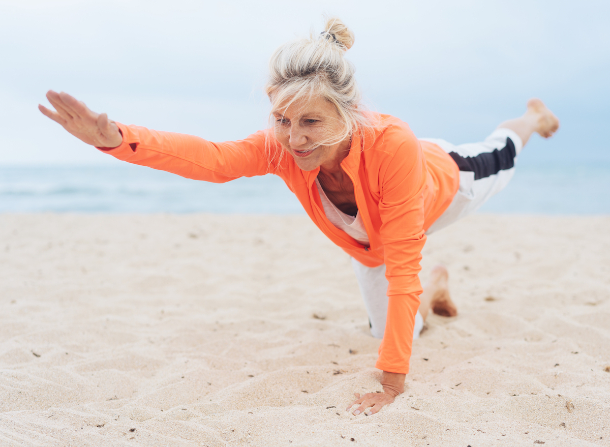 mature woman beach exercises demonstrating working out seven days a week