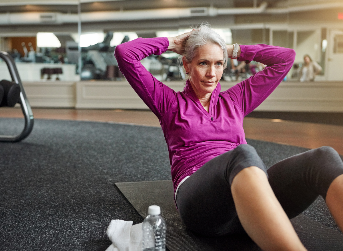 mature woman performing sit-ups for lower belly pooch workout