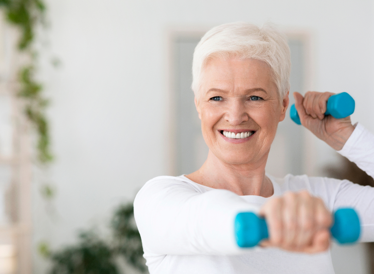 mature woman demonstrating dumbbell exercises to regain muscle mass as you age