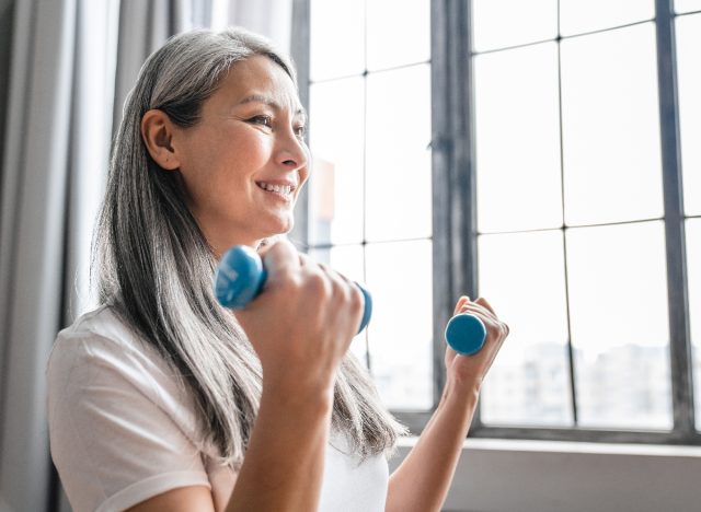 mature woman performing dumbbells workout