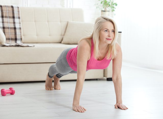 mature woman doing 60-second plank, demonstrating exercise habits for a flatter stomach