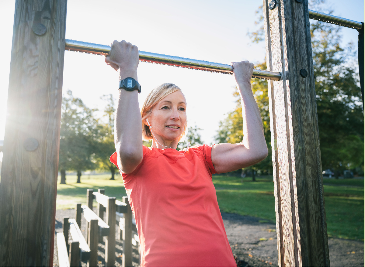 mature woman performing pull-up bar exercise tricks to slow down aging