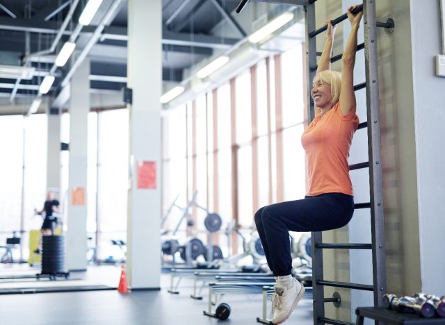 mature woman hanging onto pull-up bar