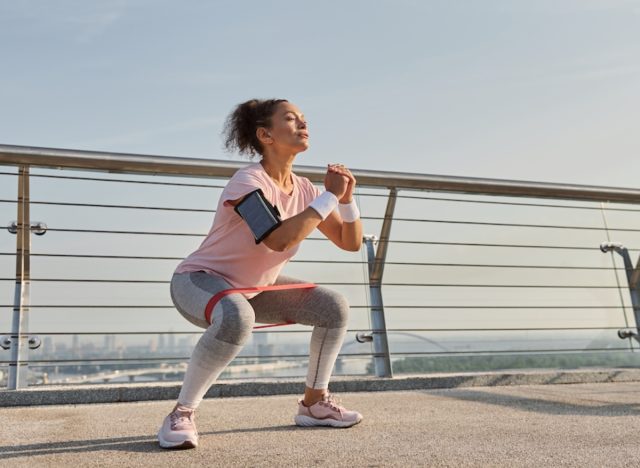 mature woman performing squats on bridge, demonstrating fitness habits that cause muscle fatigue