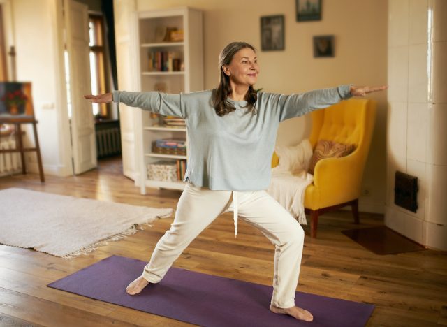 mature woman doing yoga exercises for chronic migraine pain at home