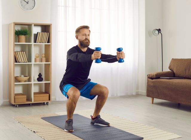 man doing dumbbell squats demonstrating how to shrink a big belly for good