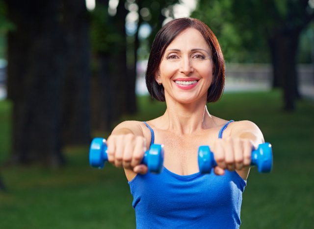 middle-aged woman with lightweight dumbbells demonstrating exercise habits for arthritis