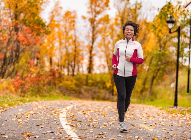 Middle-aged woman running in the fall, demonstrating the benefits of daily exercise