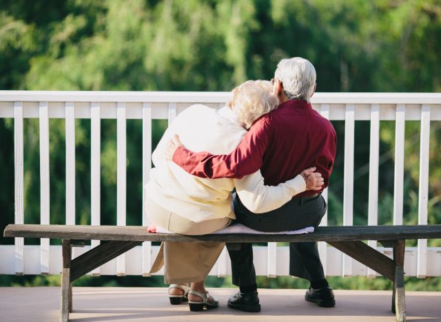 older couple cuddling on bench, demonstrating key to long-lasting marriage