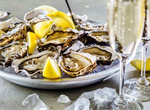 oysters with lemon wedges next to champagne in glasses