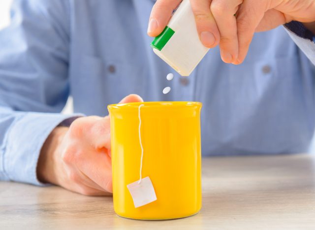 pouring sweetener tablets into tea