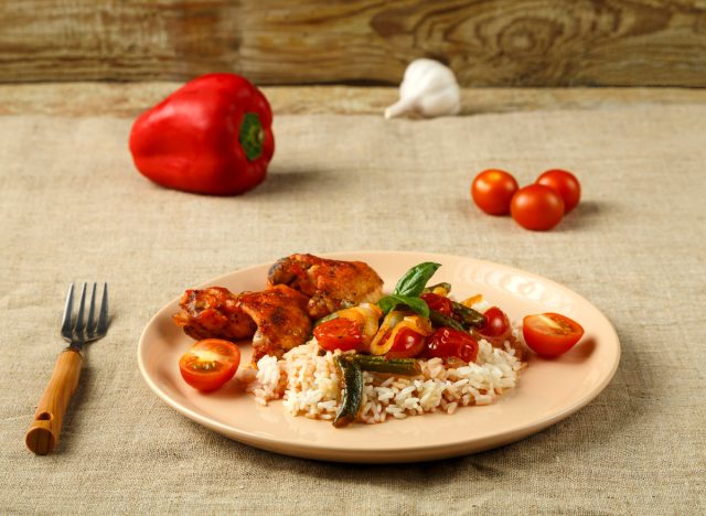 plate of chicken wings, rice, tomatoes