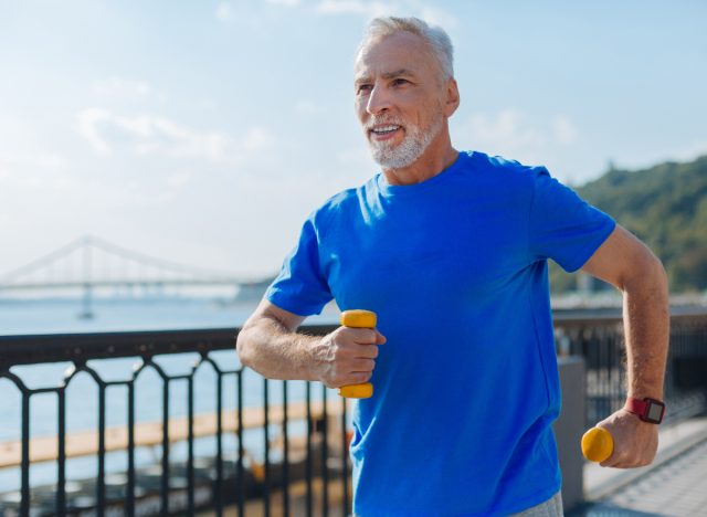 mature man using dumbbells walking, demonstrating exercising every day benefits
