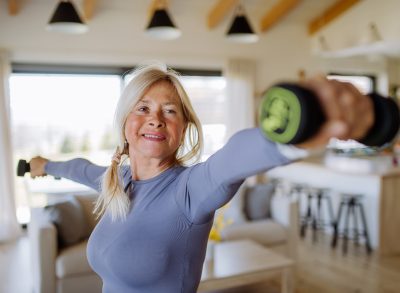 senior woman performing dumbbell exercises to slow down aging after 60
