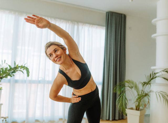 Woman doing side bending with arm extended