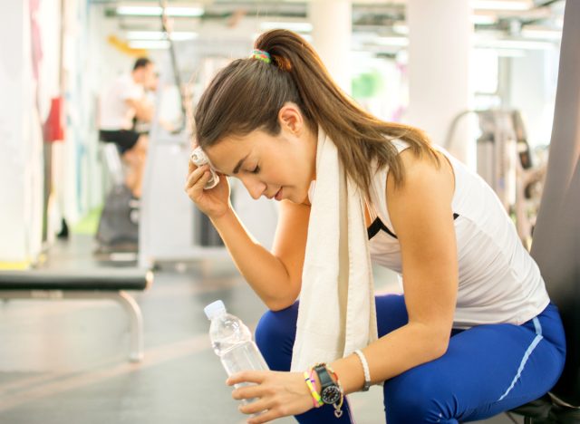tired woman during workout at gym, demonstrating when to work out while intermittent fasting