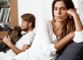 unhappy woman on couch demonstrating signs you're dating a narcissist