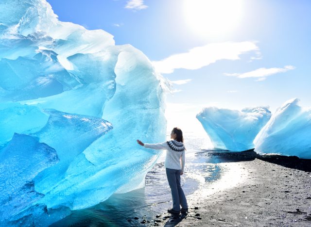 woman touching ice glacier