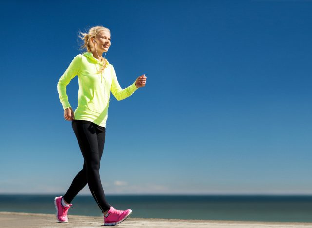 woman power walking by the beach, concept of walking to lose weight