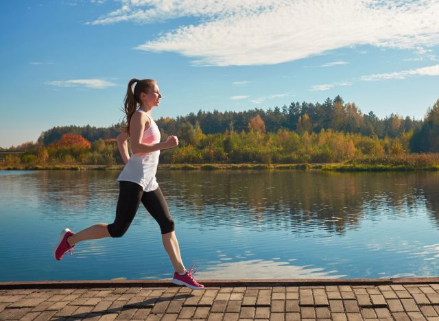 woman running by a lake in autumn, demonstrating exercises for chronic migraines
