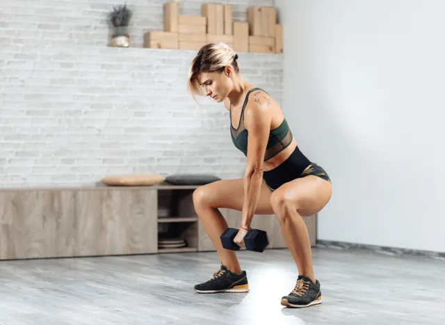 woman performing single arm dumbbell swing