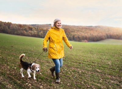 active senior woman taking her dog for a walk, demonstrating how to feel much younger than your age