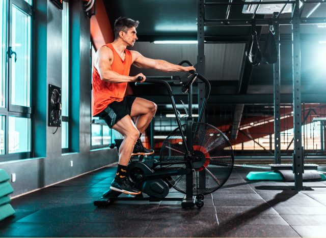 man performing air bike sprints to burn more calories than running