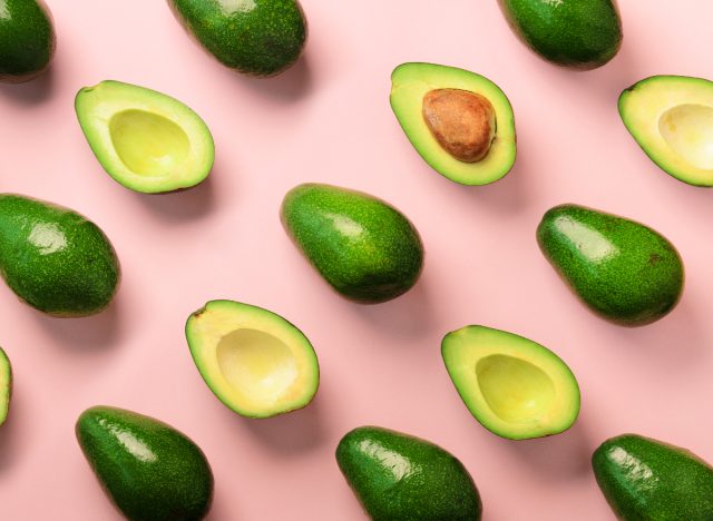 avocados on pink background, the best superfoods for a flat belly