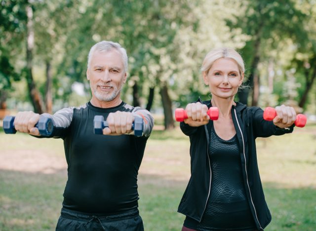 couple strength training outdoors with dumbbells, wellness habits that slow down aging