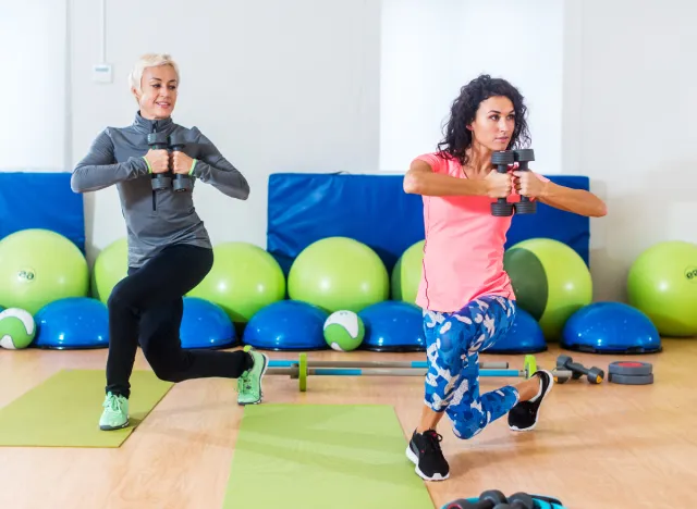 women performing dumbbell lunge twists