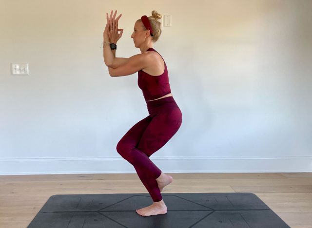 trainer performing eagle pose yoga exercises to reduce inflammation