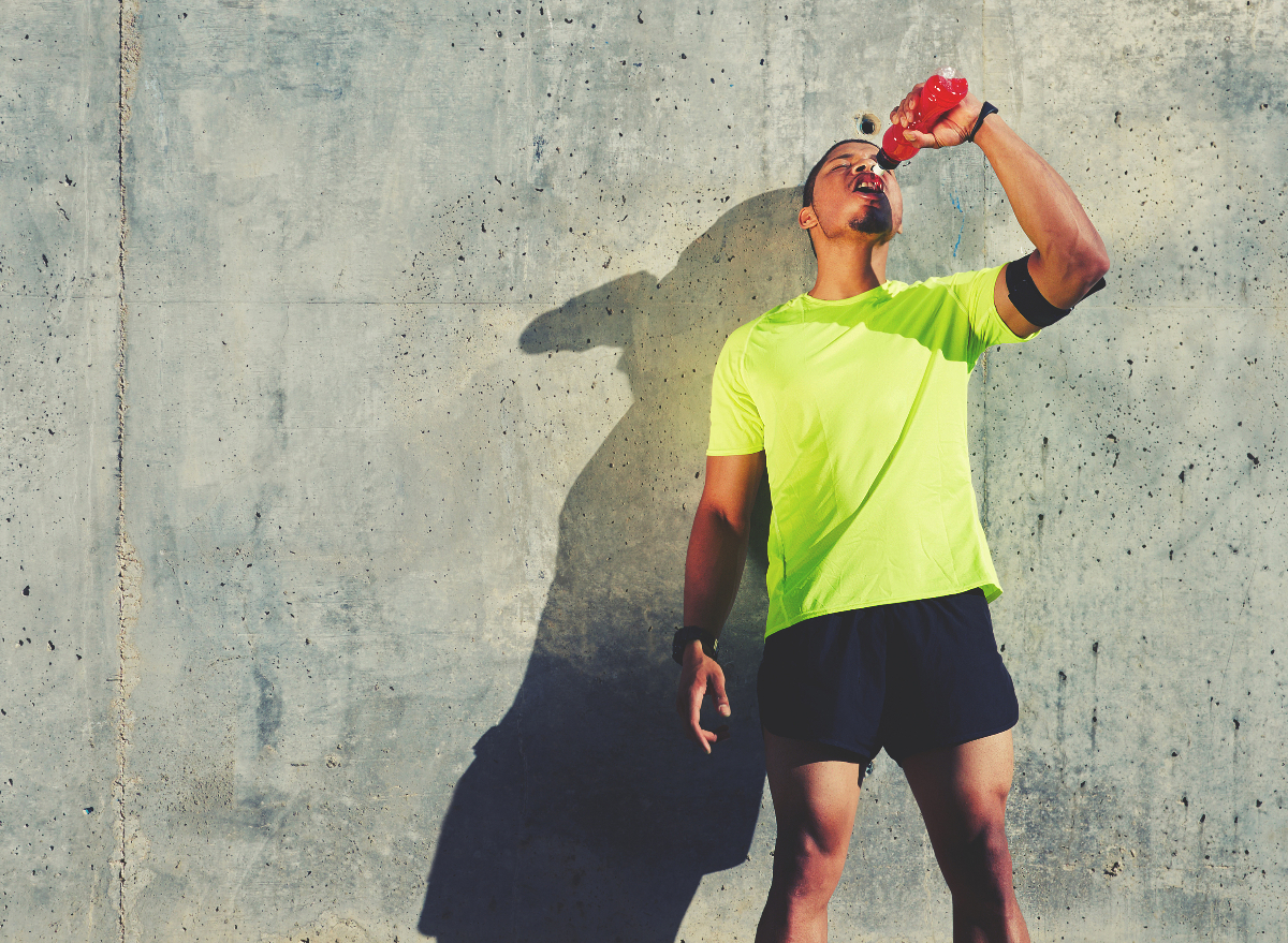 man drinking sugary energy drink, habits that give you a bigger waistline