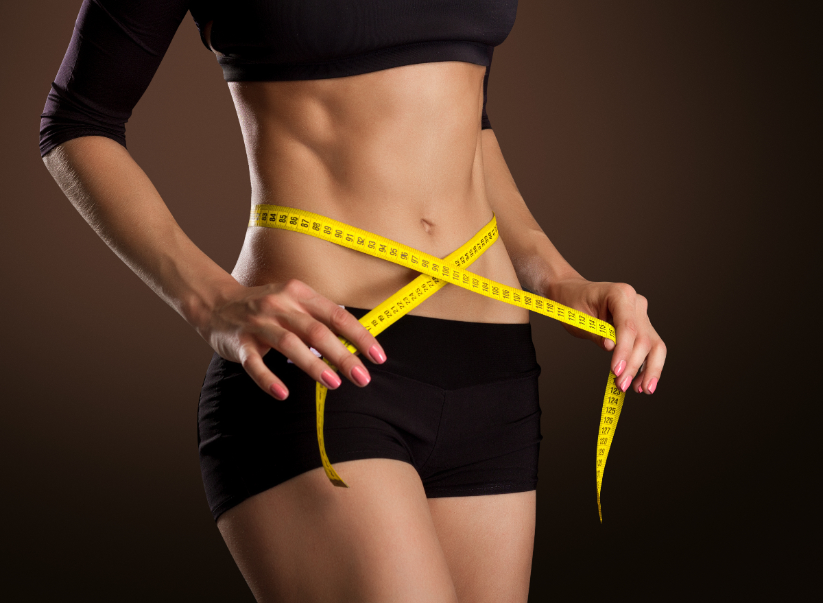 fit woman measuring waistline, concept to double your belly fat loss