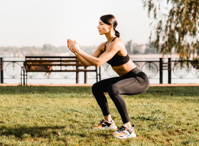 fit woman demonstrating how to lose leg fat with squats