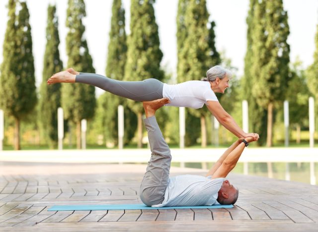 happy mature couple doing couples yoga, wellness habits that slow down aging