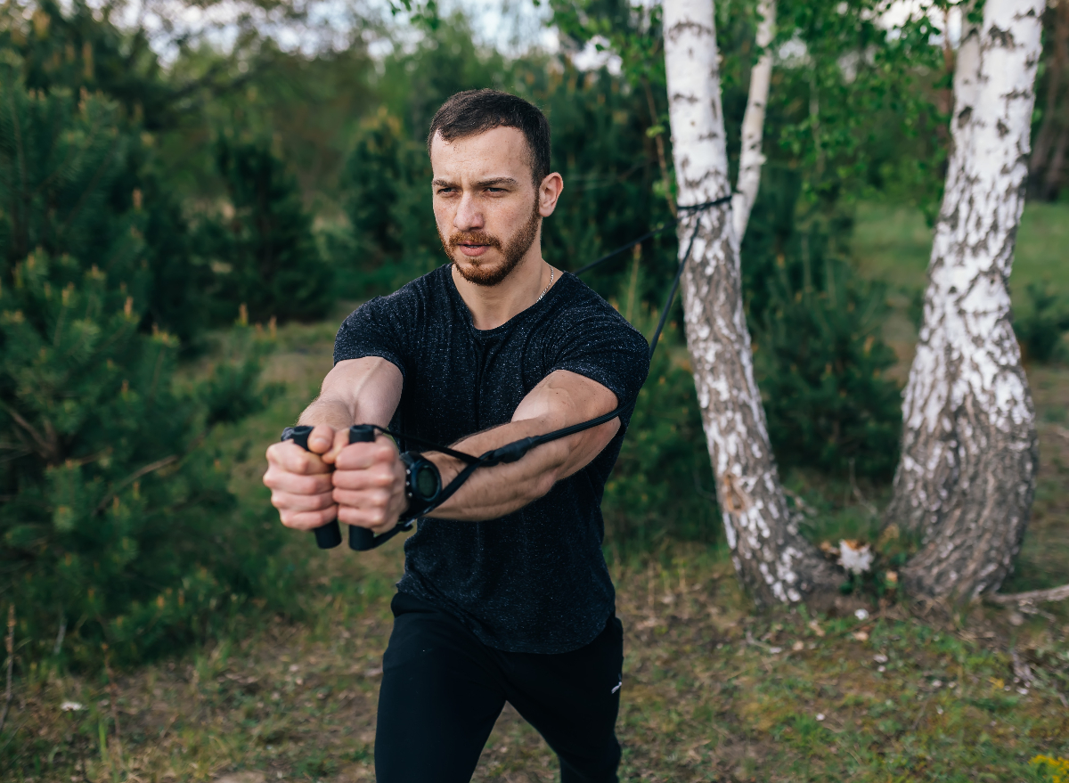 man performing lower belly fat workout with resistance band