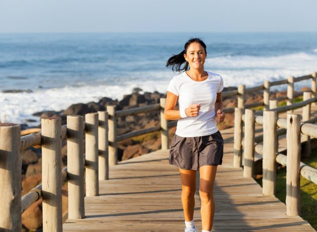 middle-aged woman running by beach, concept of joint health after lifting heavier weights