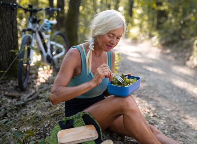 Senior woman eating healthy outside