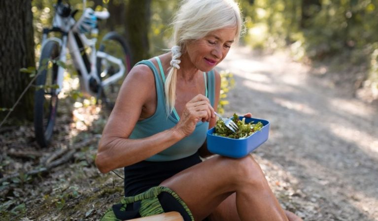 older woman eating healthy outside