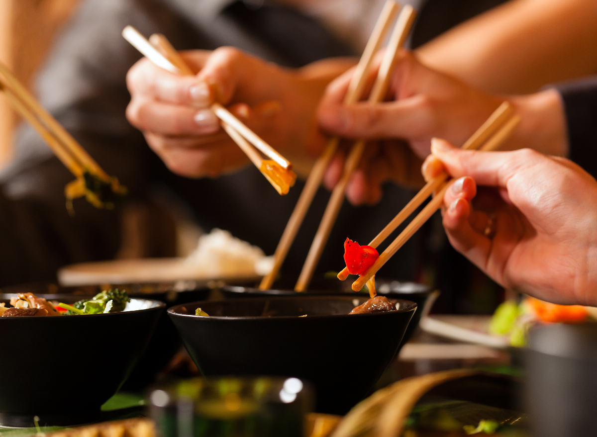 people eating thai food with chopsticks