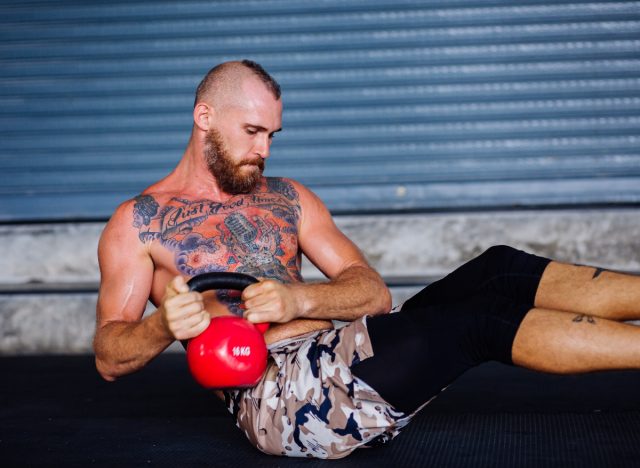 man demonstrating Russian twist exercise, workout to shrink pot belly fat