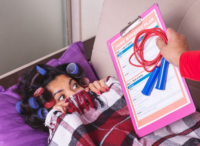 sedentary woman in curlers doesn't want to work out, demonstrates habits that give you a bigger waistline